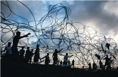  ?? MOHAMMED ABED / AFP / GETTY IMAGES ?? Palestinia­n protesters near a barbed-wire fence along the border with Israel in the central Gaza Strip on Friday.