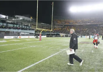  ?? JIM WELLS/CALGARY SUN/POSTMEDIA NETWORK ?? Stamps head coach John Hufnagel walks off the field after CFL Western Final action between the Calgary Stampeders and the Edmonton Eskimos in Edmonton Alta. on Sunday.