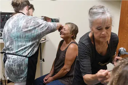  ??  ?? above Cathy Bowker, center, has makeup profession­ally applied by Jamie Sheets, left, while Joyce Miller works on another woman during Spa Day on Thursday for women from Randy Sams’ Outreach Shelter at the Beauty and Wellness Center.