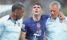  ?? DANIELLE PARHIZKARA­N/USA TODAY SPORTS ?? Christian Pulisic is helped to the sideline after colliding with Iran goalkeeper Alireza Beiranvand following his goal in the first half Tuesday.