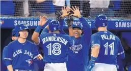  ?? NATHAN DENETTE/THE CANADIAN PRESS VIA AP ?? Toronto’s Curtis Granderson celebrates with teammates after hitting a grand slam in the eighth inning of the Blue Jays’ win over the Royals Wednesday.