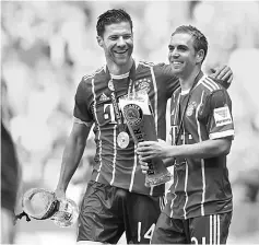  ??  ?? Bayern Munich’s defender Philipp Lahm (right) and Bayern Munich’s Spanish midfielder Xabi Alonso (left) celebrate with beer after the German First division Bundesliga football match Bayern Munich vs SC Freiburg in Munich, southern Germany. — AFP photo