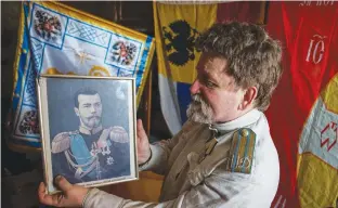  ??  ?? MIKHAIL USTINOV, 68, a self-proclaimed spokesman for the Moscow monarchist community, posing with a portrait of the last Russian tsar Nicholas II during an AFP interview in his small apartment on the outskirts of Moscow.