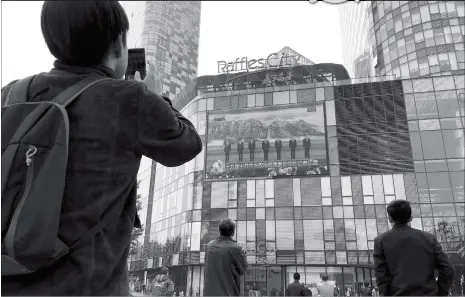  ?? Photo: AP ?? People watch a live television broadcast of new members of the Political Bureau Standing Committee of the Communist Party of China Central Committee on a shopping mall’s giant screen in Beijing on Wednesday.