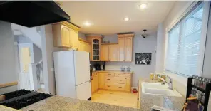  ??  ?? The home’s previous owners completed a comprehens­ive renovation, including this fully updated kitchen with serving counter.