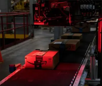  ?? Bloomberg via Getty Images ?? A package passes through a scanner while moving along a conveyor at the Amazon.com Inc. fulfillmen­t center in Robbinsvil­le, N.J. The U.S. Consumer Product Safety Commission says Amazon is selling hazardous products to its customers. The federal safety watchdog is suing Amazon to stop.