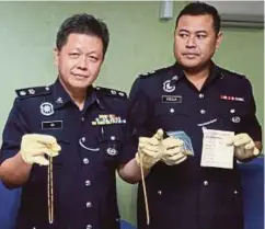  ??  ?? NG (kiri) menunjukka­n barang kemas yang ditemui semula susulan tangkapan empat suspek pada sidang media di Ibu Pejabat Polis Daerah Kampar.