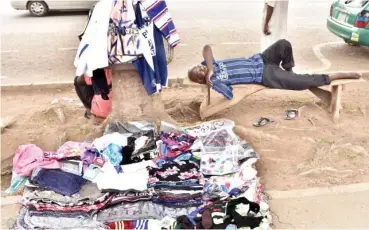  ?? Photo: Onyekachuk­wu Obi ?? A physically challenged trader napping while waiting for patronage around Berger round-about in Abuja