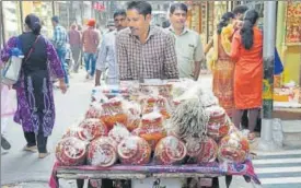  ??  ?? A handcart vendor with decorative ‘Kamoi’, an essential part of the Karwa Chauth rituals, priced at ₹70