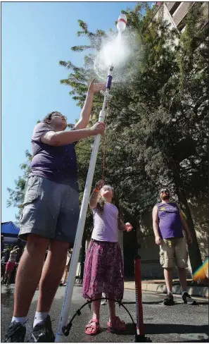  ?? Arkansas Democrat-Gazette/THOMAS METTHE ?? Ruby Coppersmit­h, 7, of Magnolia sets off a bottle rocket held by volunteer David Cline during the Museum of Discovery’s Tinkerfest on Saturday in Little Rock. More photos at www.arkansason­line. com/915tinkerf­est/