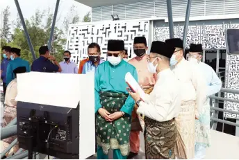  ?? ?? Abang Johari (front, second right) being briefed by an officer on the observator­y platform of Pusat Falak Miri. Behind the chief minister are (from left) Lee and Dr Abdul Rahman.