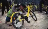  ??  ?? A worker repairs a shared bicycle at a repair center in Beijing. — AFP photos