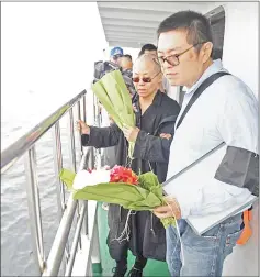  ??  ?? File photo shows Liu Xia (left) and her younger brother Liu Xiaoxuan, holding flowers as they scatter Xiaobo’s ashes at sea off the coast of Dalian, Liaoning Province. — AFP photo