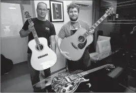  ?? STAFF PHOTO BY DARWIN WEIGEL ?? Bill Seymour, left, president of Pearl Works and Ray Jeffries, inlay production manager, hold Martin guitars that were in Larry Sifel’s private collection. On the left is the Martin D-100 anniversar­y guitar celebratin­g the firms millionth guitar and on...