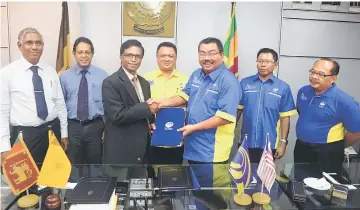  ??  ?? Tuanku Syed Faizuddin witnesses the exchange of the letter of intent between Zul Azhar (third right) and Prof Ananda Jayawardan­e. — Bernama photo