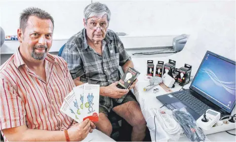  ?? FOTO: THOMAS SIEDLER ?? Wolfgang Lorenz (rechts) trainiert bei der Caritas Ost-Württember­g die angehenden Stromsparh­elfer. Flyer in verschiede­nen Sprachen informiere­n über das Projekt. Unser Bild zeigt Lorenz mit dem Leiter des Bereichs Berufliche Integratio­n, Florian Heusel.