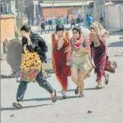 ?? AP ?? A group of girls runs for cover during a clash between local youths and paramilita­ry soldiers in Srinagar on Sunday.