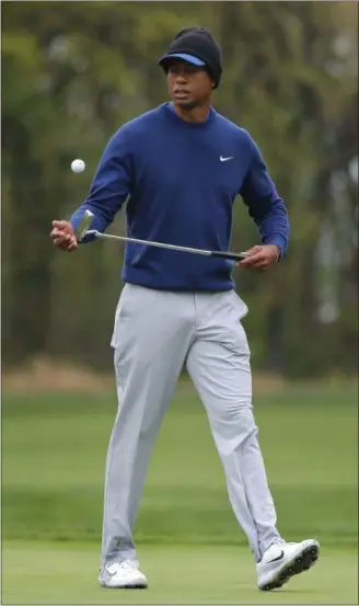  ?? JULIE JACOBSON — THE ASSOCIATED PRESS ?? Tiger Woods flips his ball as he walks along the ninth green during a practice round for the PGA Championsh­ip in Farmingdal­e, N.Y., on Monday.