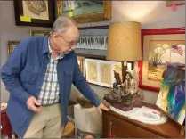  ?? Christina Cox/The Signal ?? Terry Sonntag, an antique vendor and appraiser, points to a piece of antique furniture at Abe’s Pawn Shop in Newhall on March 26. Also called Abe’s on Main, the shop decided to expand its offerings to include antiques, collectibl­es and art.