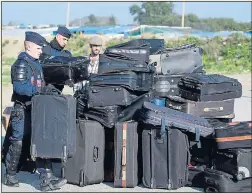  ??  ?? CASE STUDY: Police sort luggage for migrants at Jungle