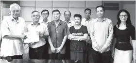  ??  ?? Tham (left) receiving SEA membership form from Yap while council members of SEA and TAS look on.