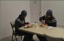  ?? Photos by Peter Loewi ?? BREAKFAST IN UNK (top)—Kristy, left, and Anna Berington read Musher Grams as they dig into a breakfast of sourdough pancakes, bacon, banana bread, orange slices, coffee, and cookies after arriving in Unalakleet about 5 AM on Monday. Kristy said by this point in the race they were craving fresh fruits and vegetables