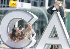  ?? MICHAEL BELL ?? Brooke Folk, Carys Karst, and Joey Herndier, from left, all students from Gladys McDonald School, play on the Canada 150 sign in Victoria Park.