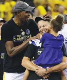  ?? THE ASSOCIATED PRESS ?? Golden State Warriors guard Stephen Curry, center, holds his daughter Riley as they celebrate with forward Kevin Durant, left, after the NBA Finals’ Game 5 against the Cleveland Cavaliers in Oakland, Calif. The Warriors won 129-120 Monday to win the...