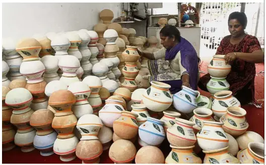  ??  ?? Meeting demand: Store keepers preparing the pots for the upcoming Ponggal celebratio­ns in Little India.