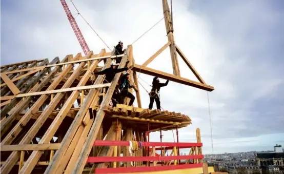  ?? DAVID BORDES/REBATIR NOTRE-DAME DE PARIS VIA NEW YORK TIMES ?? Artisans at work atop Notre-Dame in January. Below: Scaffoldin­g around the cathedral in March; carpenter Hank Silver.