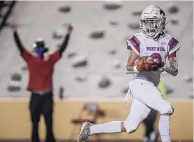  ?? ROBERTO E. ROSALES/JOURNAL ?? With a West Mesa coach giving the touchdown signal in the background, Mustangs sophomore receiver Chris Johnson catches a scoring pass Friday against Sandia.