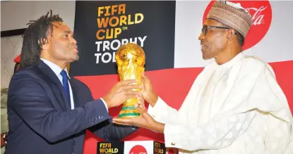  ?? Photo: Felix Onigbinde ?? FIFA’s representa­tive, Christian Karembeu (left), presents the FIFA/ Cocacola World Cup’s trophy to President Muhammadu Buhari at the Presidenti­al Villa in Abuja yesterday