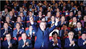  ?? - Reuters ?? JUBILANT: Moon Jae-in, the presidenti­al candidate of the Democratic Party of Korea, poses for photograph­s as he watches a television report on an exit poll of the presidenti­al election in Seoul, South Korea on Tuesday.