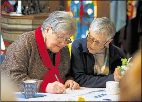  ??  ?? Erika Catchpole and Jeanette Reid-Marr get stuck into the quiz at St Nicholas Church in Maidstone