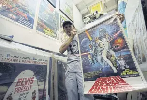  ??  ?? Santi Tantipunta­rux shows the rare Star Wars poster with the fake title The War Of The World.