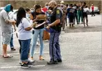  ??  ?? People fill out paperwork while waiting in line before getting vaccinated at St. Philip AME Church this month. Senior Pastor the Rev. William D. Watley’s 91-year-old mother survived a bout of COVID-19.