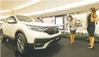  ?? PUGUH SUJIATMIKO/JAWA POS ?? TANPA UANG MUKA: Pengunjung berbincang dengan penjaga stan pameran otomotif di Surabaya pada akhir pekan lalu.