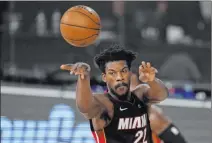  ?? Mark J. Terrill The Associated Press ?? Miami’s Jimmy Butler passes in the first half of a Game 5 triumph over the Milwaukee Bucks that puts the Heat in the East finals.