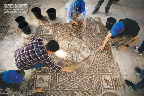  ??  ?? ARCHEOLOGI DELL’AUTORITÀ ISRAELIANA PER LE ANTICHITÀ PULISCONO UNA PARTE DEL MOSAICO APPENA SCOPERTO.