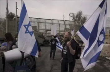  ?? Leo Correa/AP photo ?? People stand in front of a gate at the Nitzana border crossing with Egypt in southern Israel on Monday, in a protest against humanitari­an aid entering Gaza until all the hostages are released.