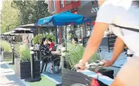  ?? RICHARD LAUTENS TORONTO STAR FILE PHOTO ?? City council has approved the return of CaféTO, a program that lets eateries expand patios into public and private spaces.