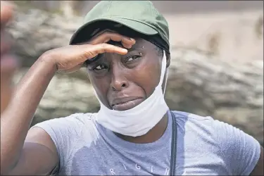  ?? GERALD HERBERT — THE ASSOCIATED PRESS ?? Linda Smoot, who evacuated from Hurricane Laura in a pickup truck with eight others, reacts as they return to see their homes, in Lake Charles, Louisiana, in the aftermath of the hurricane, Aug. 30.