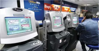  ??  ?? Addictive: Fixed-odd betting terminals in a William Hill betting shop