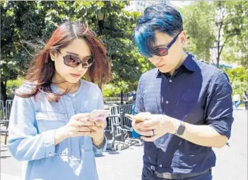  ?? Justin Lane EPA ?? UNLIKE CONVENTION­AL computer and console games that demand a player’s full attention, “Pokemon Go” can be consumed in bite-size increments throughout the day. Above, players at Union Square in New York.