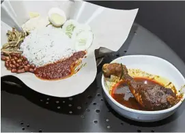  ??  ?? The real deal: The national dish nasi lemak is traditiona­lly served with chicken rendang which is not meant to be crispy as suggested by Wallace. — AP