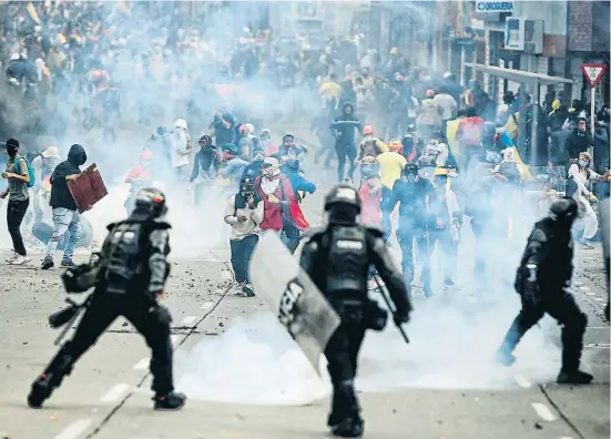  ?? PABLO RODRIGUEZ / EFE ?? Jóvenes manifestan­tes se enfrentan a los antidistur­bios de la policía colombiana en la Loma de la Cruz, en Cali