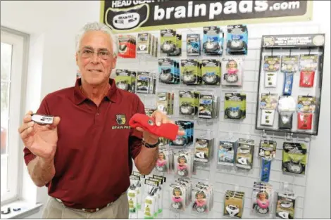  ?? GENE WALSH/FOR THE REPORTER ?? JOSEPH MANZO, CEO and president of Brain-Pad Inc., poses with two of his company’s products: the 3XS Jaw Joint Protector and the Impact Protective head band.