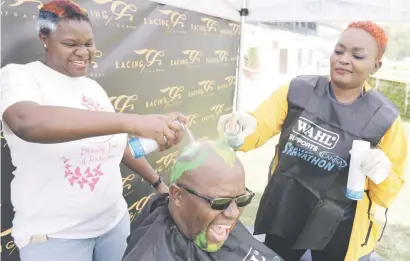  ?? Picture: Refilwe Modise ?? Phumelela betting staff spray a co-worker’s head at Turffontei­n Racecourse yesterday in support of cancer awareness.
