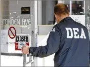  ?? STAFF FILE PHOTO 2012 ?? A federal drug enforcemen­t agent enters the Kirkwood Family Practice on Linden Avenue in Dayton while serving a search warrant on the property.