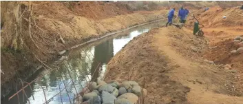  ??  ?? Constructi­on workers put final touches to the refurbishe­d canal at Nyanyadzi Irrigation Scheme